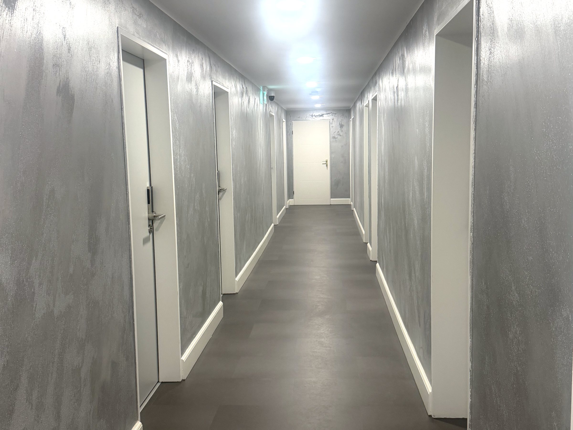 Beleuchteter Flur mit Zimmertüren im City Event Hotel Dinslaken